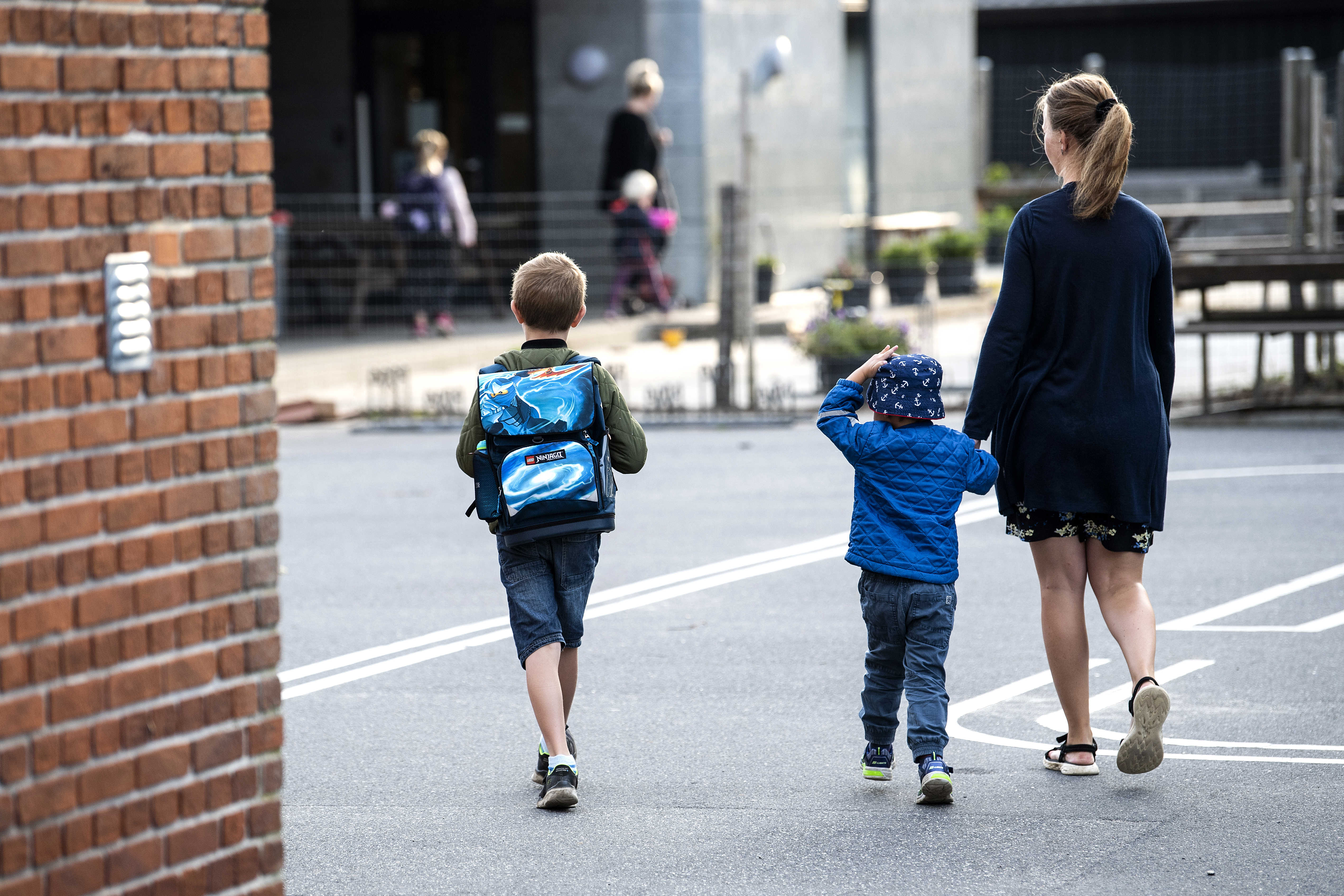 Mor og børn på vej til skole